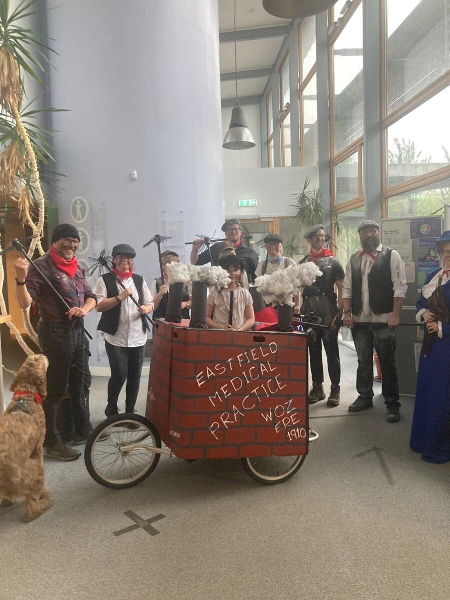 Eastfield staff dressed as Victorian chimney sweeps around a community-event float